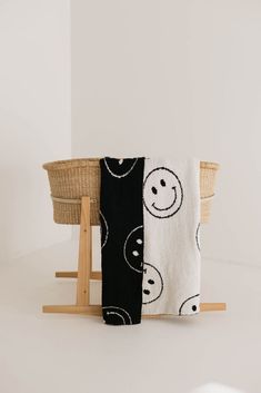 two towels sitting next to each other on top of a wooden stand in front of a white wall