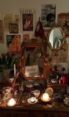 a dresser with many items on top of it and a mirror above the desk in front of it