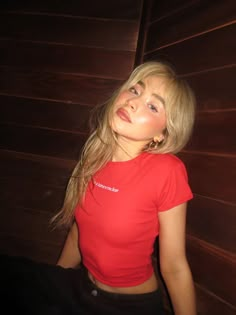 a woman in a red shirt posing for the camera