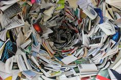 a pile of books that are sitting on top of each other in the middle of a room