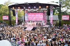 a large group of people standing on top of a stage in front of a crowd