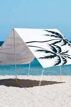 an upside down umbrella on the beach next to the ocean