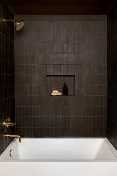 a white bath tub sitting inside of a bathroom next to a wall mounted faucet