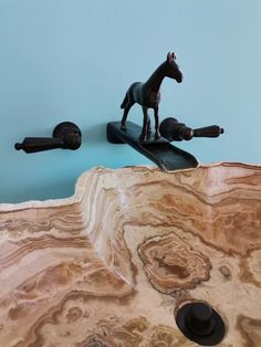 a horse figurine sitting on top of a wooden table next to other items