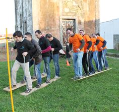 a group of men standing on top of wooden planks in front of an old building