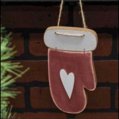 an oven mitt ornament hanging on a brick wall