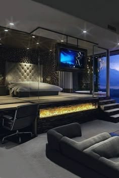 a bedroom with a large bed, couches and a flat screen tv on the wall