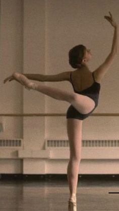 a young ballerina is practicing her ballet moves