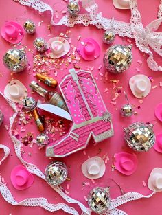 a pink table topped with lots of confetti and other items on top of it