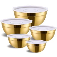 four gold and white bowls with lids on each one, set against a white background