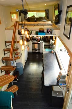 the interior of a tiny house with stairs leading up to the loft and kitchen area