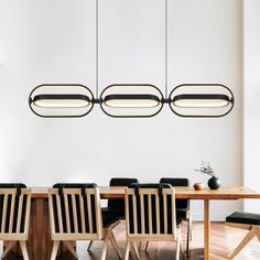 a dining room table with chairs and lights hanging from the ceiling