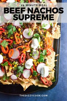 a tray filled with beef nachos topped with sour cream and cilantro