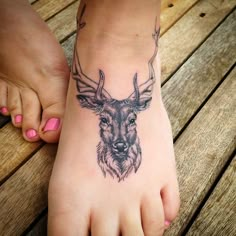 a close up of a person's foot with a deer tattoo on it