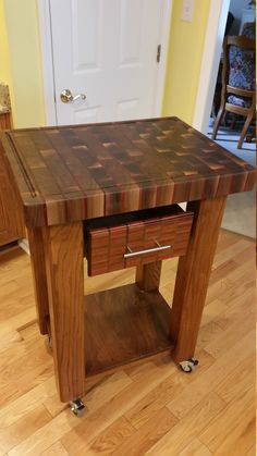 a wooden table with two drawers on it in the middle of a floored room