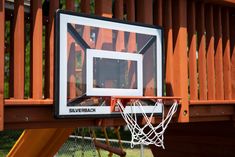 a basketball hoop is attached to the backboard of a wooden play area with an orange slide