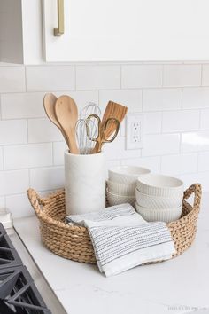 kitchen utensils are in a basket on the counter