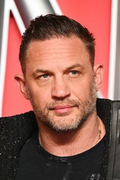 a close up of a person wearing a black shirt and holding a microphone in his hand