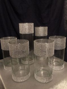 four clear glass vases sitting on top of a table