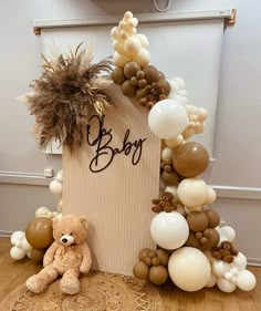 a teddy bear sitting in front of a birthday sign with balloons and decorations around it