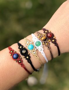 a woman's arm with four different bracelets on top of each other,