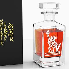 an empty glass bottle with the statue of liberty on it next to a black box