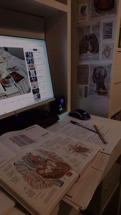 a computer monitor sitting on top of a desk next to a bunch of papers and pens