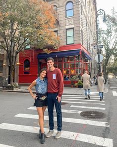 a man and woman standing in the middle of a cross walk