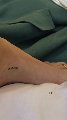 a woman's foot with the word mom tattooed on her left ankle and an arrow at the bottom