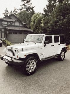 a white jeep parked in front of a house