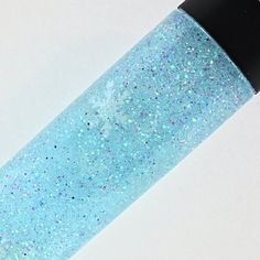 a blue bottle with glitter on it sitting on a table