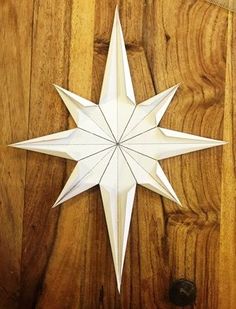 a white origami star hanging on a wooden door