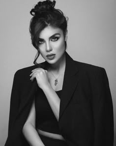 black and white photo of a woman in a suit with her hand on her shoulder