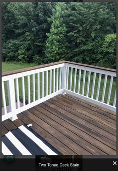 a wooden deck with black and white striped rugs on the bottom half of it