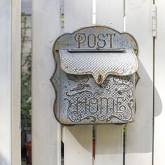 an old fashioned mailbox mounted on a white picket fence with the word top written below it