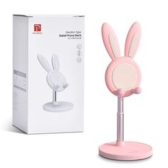 a pink microphone with bunny ears on it next to a white box and cardboard package