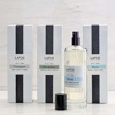 three bottles of lafco cologne sitting next to each other on a white surface