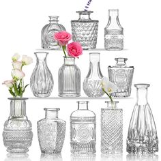 many different vases and flowers are arranged on a shelf with one pink flower in the middle