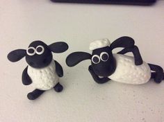 two black and white sheep figurines sitting next to each other