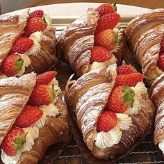 several croissants with strawberries and cream on them