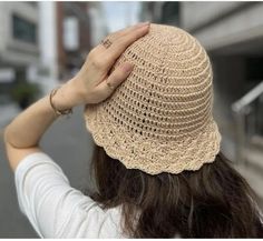 a woman with long hair wearing a beige hat