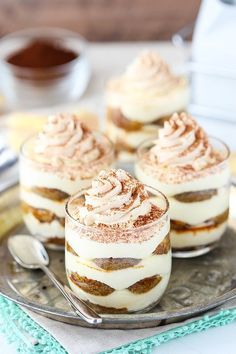 three desserts are sitting on a plate with spoons next to eachother