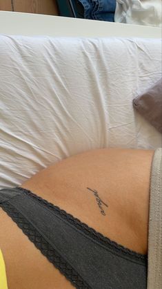 a woman laying in bed with her stomach tattoo