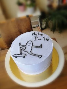 a white cake with black writing on it sitting on top of a table next to a brown chair