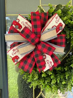 a red and black plaid christmas wreath hanging on a door