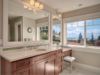 a large bathroom with marble counter tops and wooden cabinets