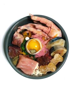 a bowl filled with different types of meats and other foods on top of it