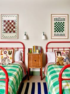 two twin beds in a bedroom with striped rugs and pictures on the wall above them