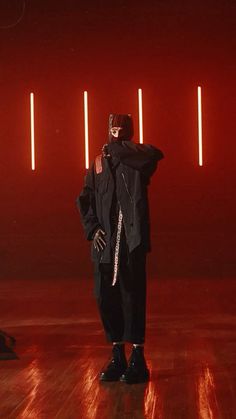 a man standing on top of a hard wood floor in front of red light beams