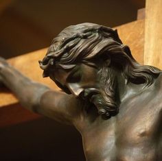 a statue of jesus holding the cross with his hands